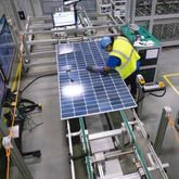 A worker makes a visual inspection of one of the solar panels as it moves through the automated assembly line at the Qcells module production facility in Cartersville on Tuesday, April 2, 2024.  (Steve Schaefer/steve.schaefer@ajc.com)