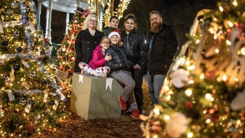 Leah Ashe, left, and Xavier Ashe, right, pose with their children Emily Ashe, 10, front left, Xander, 10, front right, Leo Nunez, 15, center left, and Gito Nunez, 17, center right, at Marietta Square. Leah, Xavier and their children are vaccinated. (BRANDEN CAMP FOR THE ATLANTA JOURNAL-CONSTITUTION)