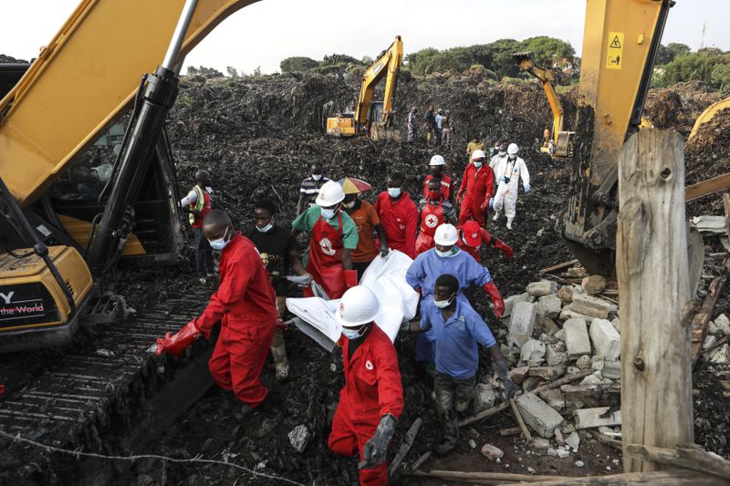 Red Cross personnel carry the body of a victim at the site of a collapsed landfill in Kampala, Uganda, Sunday, Aug. 11, 2024. (AP Photo/Hajarah Nalwadda)