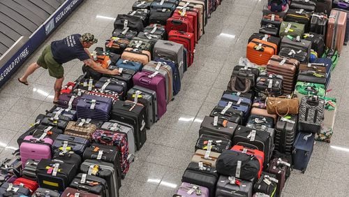 Rows of baggage sit on the floor in the baggage claim area of the domestic terminal at Hartsfield-Jackson Atlanta International Airport on July 23,  the fifth day of a massive global technology outage that severely affected the operations of Delta Air Lines. (John Spink/The Atlanta Journal-Constitution)