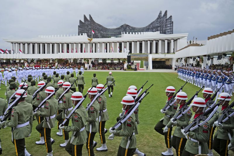 Soldiers march before the start of a ceremony marking Indonesia's 79th anniversary of the independence at the new presidential palace in its future capital city of Nusantara, still under construction on the island of Borneo, Thursday, Aug. 17, 2024. (AP Photo/Achmad Ibrahim)