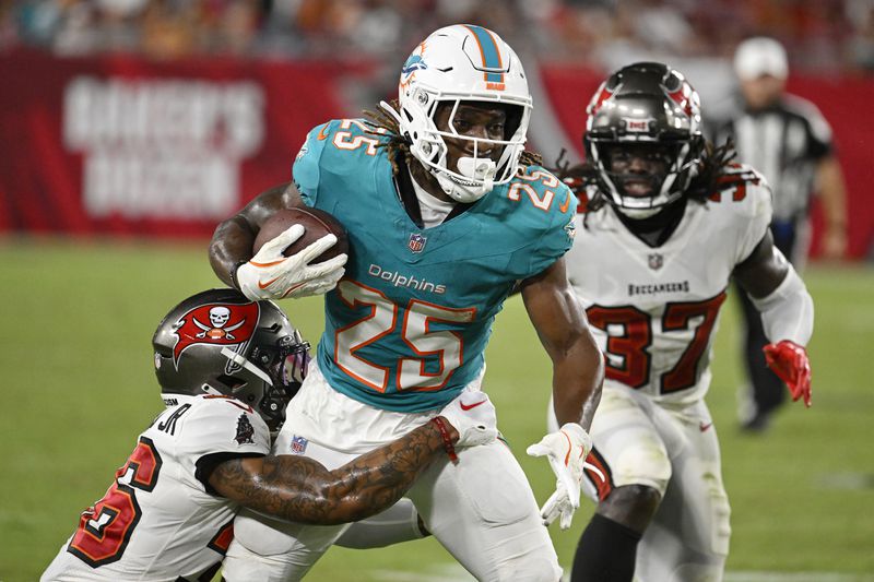 Tampa Bay Buccaneers cornerback Chris McDonald Jr. (36) tackles Miami Dolphins running back Jaylen Wright (25) during the second half of a pre season NFL football game, Friday, Aug. 23, 2024, in Tampa, Fla. (AP Photo/Jason Behnken)