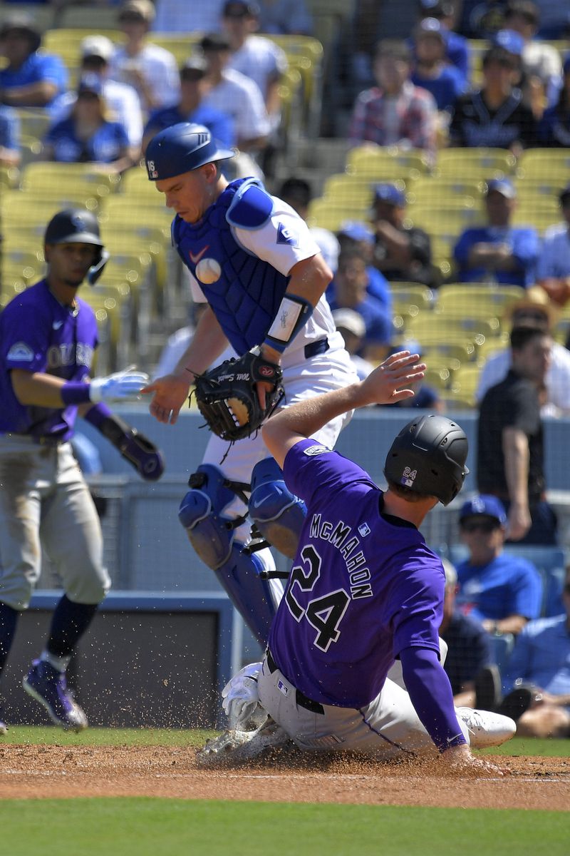 Colorado Rockies' Ryan McMahon, right, scores on a single by Brendan Rodgers as Los Angeles Dodgers catcher Will Smith takes a late throw during the first inning of a baseball game, Sunday, Sept. 22, 2024, in Los Angeles. (AP Photo/Mark J. Terrill)