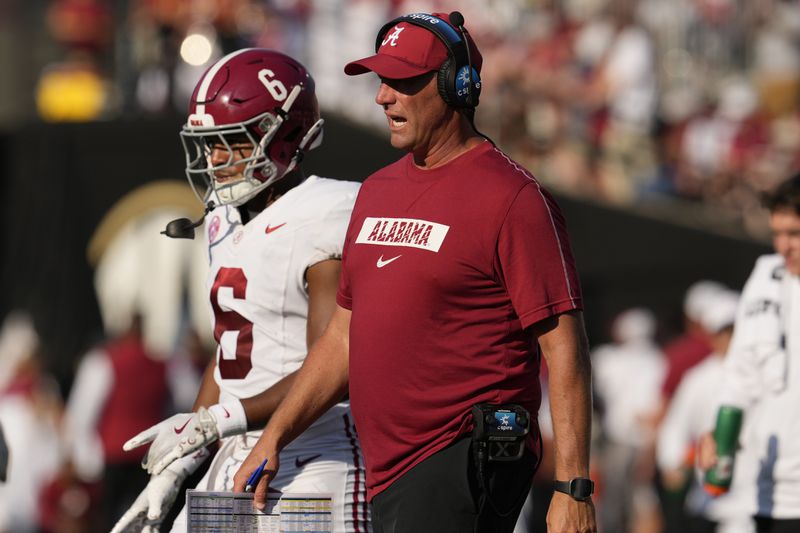 Alabama head coach Kalen DeBoer, right, walks onto field during the first half of an NCAA college football game against Vanderbilt, Saturday, Oct. 5, 2024, in Nashville, Tenn. (AP Photo/George Walker IV)