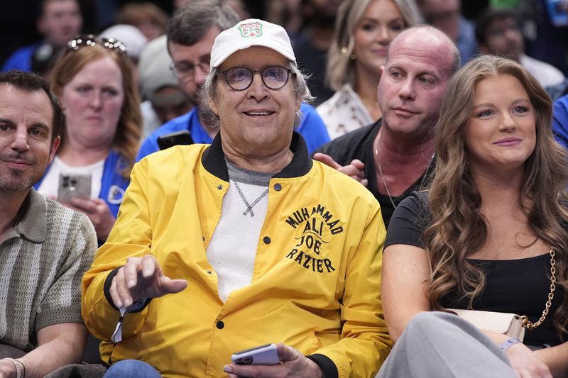 FILE - Actor Chevy Chase, center, sits on the front row during the second half of an NBA basketball game between the Atlanta Hawks and Dallas Mavericks in Dallas on April 4, 2024. (AP Photo/LM Otero, File)