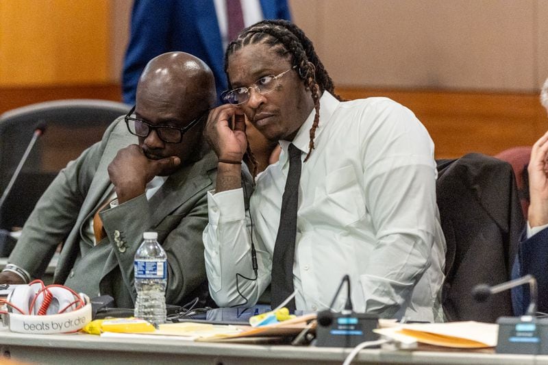 Atlanta rapper Young Thug, whose real name is Jeffery Williams, listens to a meeting with the judge with his attorney, Keith Adams, before the opening statements of his trial at Fulton County Courthouse on Monday, Nov. 27, 2023.   (Steve Schaefer/steve.schaefer@ajc.com)