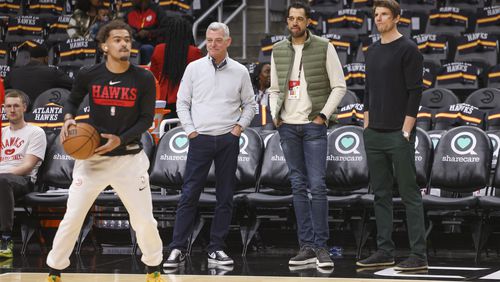 Hawks guard Trae Young prepares to shoot while (from left) Hawks owner Tony Ressler, general manager Landry Fields and assistant GM Kyle Korver watch before the Hawks’ game against the Cleveland Cavaliers at State Farm Arena, Friday, Feb. 24, 2023, in Atlanta.