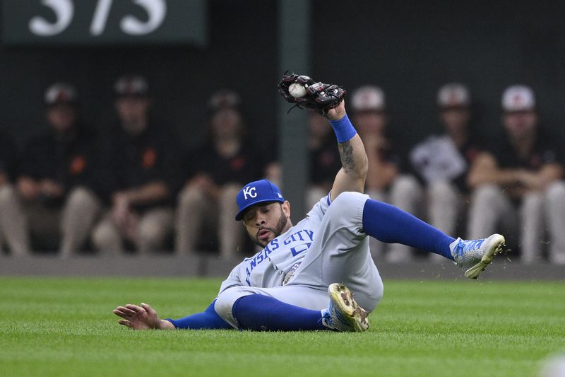 Kansas City Royals right fielder Tommy Pham (22) slides on the grass after he made a catch on a fly ball by Baltimore Orioles' Ryan Mountcastle for an out in the second inning during Game 1 of an AL Wild Card Series baseball game, Tuesday, Oct. 1, 2024, in Baltimore. (AP Photo/Nick Wass)