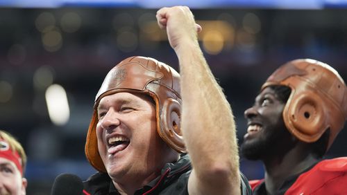 Georgia head caoch Kirby Smart wears the Old Leather helmet as he celebrates after defeating Clemson inn the Aflac Kickofff Classic NCAA college football game Aug. 31, 2024, in Atlanta. (AP Photo/John Bazemore)