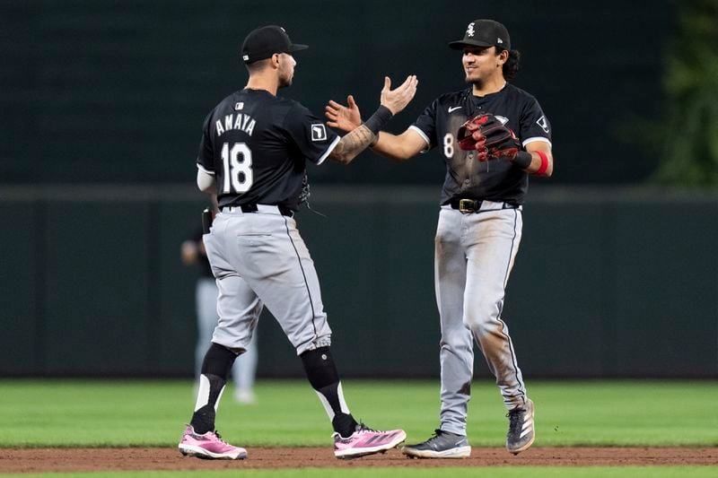 Chicago White Sox shortstop Jacob Amaya (18) and second baseman Nicky Lopez (8) celebrate their team's win over the Baltimore Orioles after a baseball game, Wednesday, Sept. 4, 2024, in Baltimore. (AP Photo/Stephanie Scarbrough)