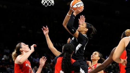 Las Vegas Aces center A'ja Wilson, center top, goes up to shoot over Atlanta Dream forward Lorela Cubaj (19) and guard Jordin Canada, center front, during the first half of a WNBA basketball game Friday, Aug. 30, 2024, in Las Vegas. (Steve Marcus/Las Vegas Sun via AP)