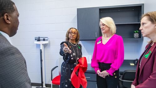 Lynne Meadows, Fulton County Schools' director of district health services, gives a tour of the private exam rooms at the opening of Fulton County’s first school-based health center at Banneker High School in College Park on Wednesday, Jan. 31, 2024. Fulton school board members Kristin McCabe and Katha Stuart are to the right. (Jenni Girtman for The Atlanta Journal-Constitution)