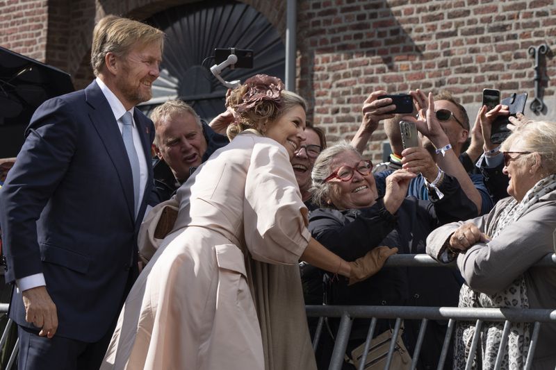 Dutch King Willem-Alexander and Queen Maxima pose for a selfie with a well-wisher during a ceremony marking the 80th anniversary of the liberation of the south of the Netherlands in Mesch, Thursday, Sept. 12, 2024. (AP Photo/Peter Dejong)