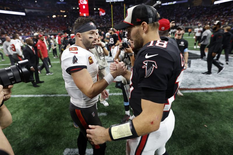 Atlanta Falcons quarterback Kirk Cousins (18) shakes hands with Tampa Bay Buccaneers quarterback Baker Mayfield after the Falcons defeated the Buccaneers during overtime in an NFL football game Friday, Oct. 4, 2024, in Atlanta. (AP Photo/Butch Dill)