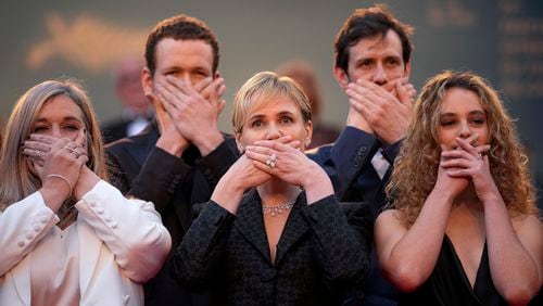 FILE "- Me Too" director Judith Godreche, center, poses with hands covering their mouth upon arrival at the premiere of the film 'Furiosa: A Mad Max Saga' at the 77th international film festival, Cannes, southern France, Wednesday, May 15, 2024. French film director Benoit Jacquot accused by multiple actors of sexual assault and violent, controlling behavior, including when his alleged victims were teenagers, has been handed preliminary charges of rape, sexual assault and violence by a French judge investigating the case, the Paris prosecutor's office said Thursday,July 4, 2024. Godrèche, who alleges that Jacquot raped and physical abused her in a six-year relationship that started when she was 14, has taken a lead role in kickstarting the #MeToo wave, which struggled for traction before she spoke out and emboldened other actors to do so, too. (Photo by Andreea Alexandru/Invision/AP, File)