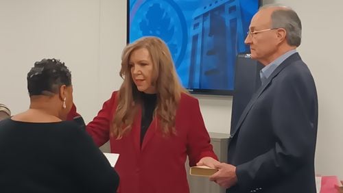 Julie Adams (center) is sworn in as a member of the Fulton County Board of Registration & Elections on Feb. 8. Clerk of Courts Che' Alexander (left) administers the oath, and Mike Heekin, Adams' fellow Republican board member, holds a Bible.