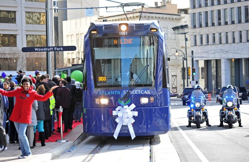 December 30, 2014 Atlanta - Crowds gather as an Atlanta Streetcar arrives during a grand opening ceremony at Woodruff Park on Tuesday, December 30, 2014. After escalating costs and a series of delays, the Atlanta street car finally rolled through a stretch of downtown Atlanta. President Obama's transportation legacy hinges on his ability to move the nation toward rail, and the streetcar is one of the first completed projects aimed at making the nation more rail oriented. And the city sees the streetcar as the first of many streetcars that will create an auxiliary transit system over time, attracting investment and creating jobs. HYOSUB SHIN / HSHIN@AJC.COM