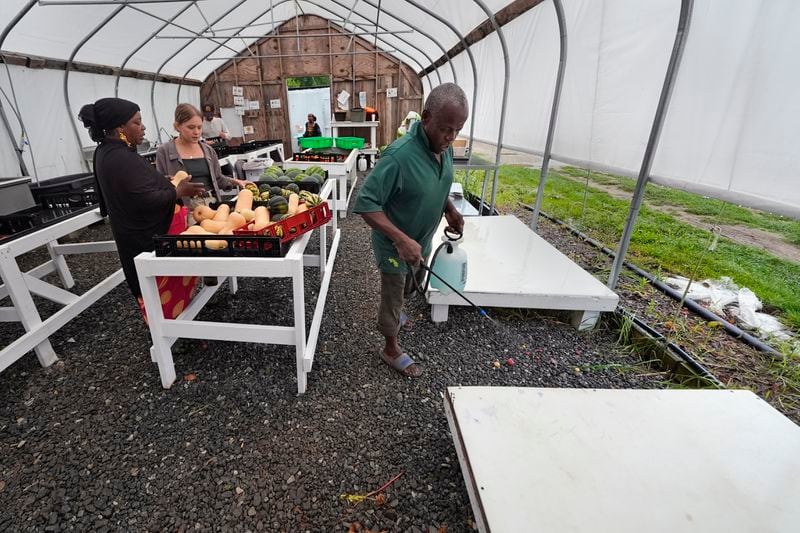 A packing platform is sanitized as harvested vegetables begin to arrive at a processing greenhouse at Fresh Start Farm, Aug. 19, 2024, in Dunbarton, N.H. (AP Photo/Charles Krupa)