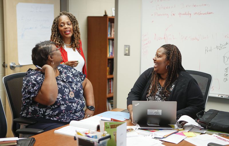 Harper-Archer Elementary School Principal Dione Simon Taylor, far right, goes over schedules and makes plans with the school’s business manager Shonda Fulton, at left, and  LaJuana Ezzard, center, director of the school’s programs and partnerships.    Bob Andres / robert.andres@ajc.com