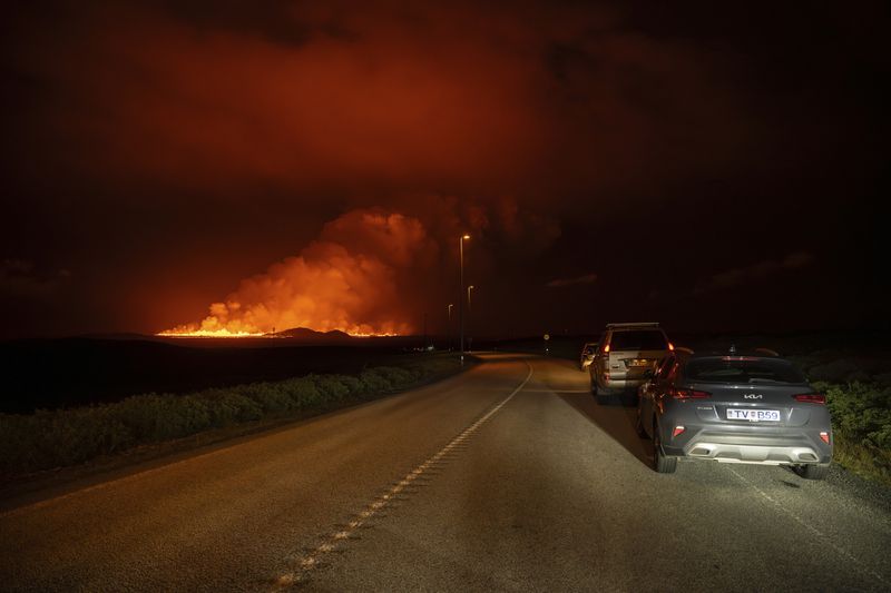 A new volcanic eruption is seen from the intersection between Reykjanesbraut, Iceland, and the road to Grindavik, Thursday, Aug. 22, 2024. (AP Photo/Marco di Marco)