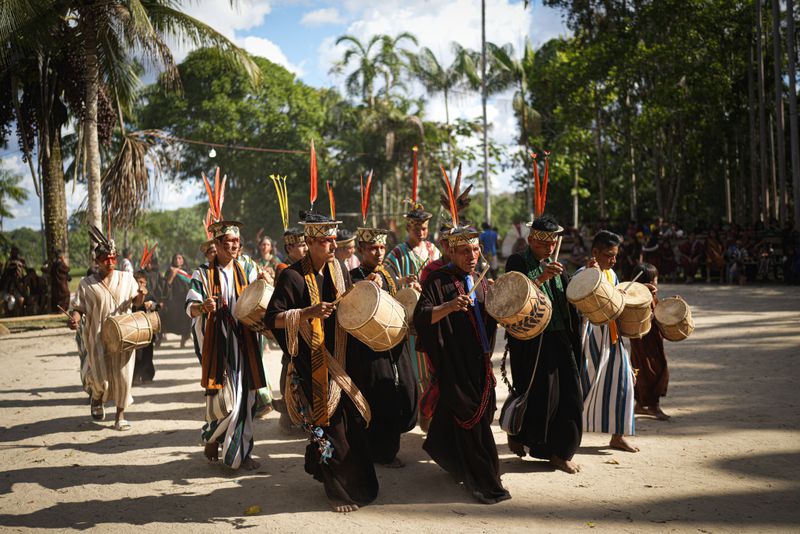 Ashaninka Indigenous musicians from Brazil and Peru perform during the annual celebration recognizing the Ashaninka territory in the Apiwtxa village, Acre state, Brazil, Monday, June 24, 2024. (AP Photo/Jorge Saenz)