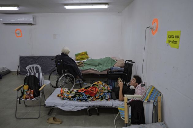 Israelis rest in a residential building bomb shelter to stay safe from rockets fired from Lebanon, in Kiryat Haim, northern Israel, on Tuesday, Sept. 24, 2024. (AP Photo/Baz Ratner)