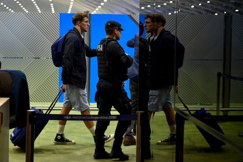 French rugby player Oscar Jegou, left, rolls a suitcase at the airport in Buenos Aires, Argentina, Tuesday, Sept. 3, 2024. Argentine prosecutors decided to let Jegou and teammate Hugo Auradou leave the country despite the two players remaining under investigation for alleged rape. (AP Photo/Gustavo Garello)