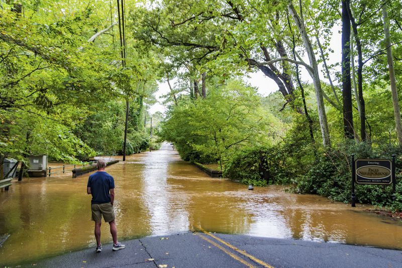 A patron looks at the flooding from Hurricane Helene in the Paces neighborhood, Friday, Sept 27, 2024, in Atlanta. (AP Photo/Jason Allen)