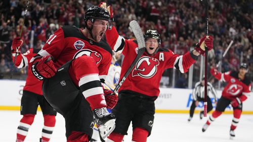 New Jersey Devils' Stefan Noesen, left, celebrates after scoring the opening goal during the NHL hockey game between Buffalo Sabres and New Jersey Devils, in Prague, Czech Republic, Friday, Oct. 4, 2024. (AP Photo/Petr David Josek)