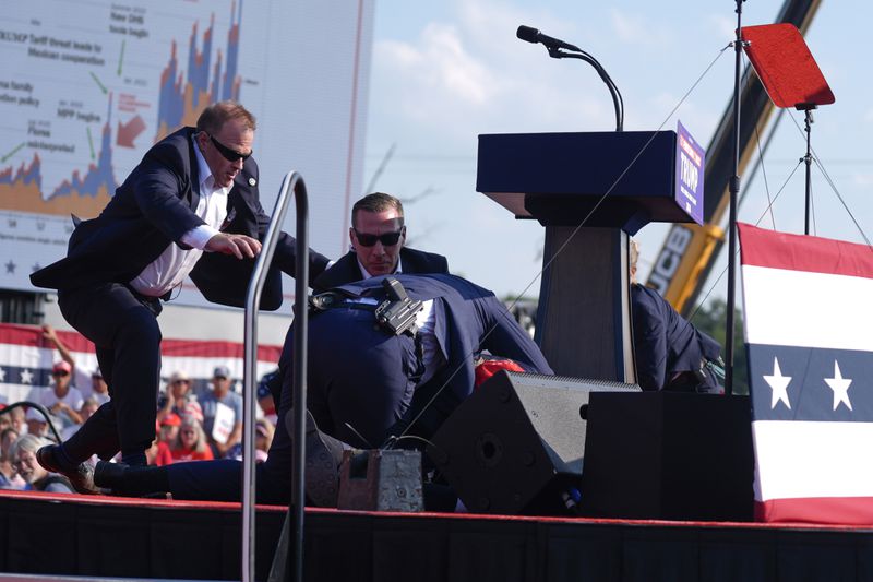 U.S. Secret Service agents converge to cover Republican presidential candidate former President Donald Trump during a campaign rally, Saturday, July 13, 2024, in Butler, Pa. (AP Photo/Evan Vucci)