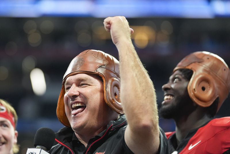 Georgia head caoch Kirby Smart wears the Old Leather helmet as he celebrates after defeating Clemson inn the Aflac Kickofff Classic NCAA college football game Aug. 31, 2024, in Atlanta. (AP Photo/John Bazemore)