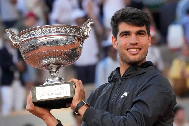 Spain's Carlos Alcaraz holds the trophy after winning the men's final of the French Open tennis tournament against Germany's Alexander Zverev at the Roland Garros stadium in Paris, France, Sunday, June 9, 2024. (AP Photo/Christophe Ena)