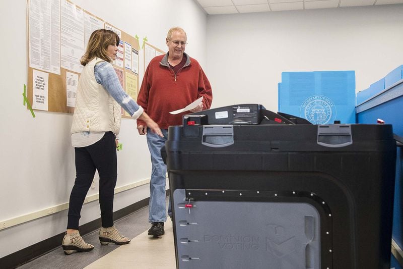 Gwinnett County poll worker Joyce Davis assists Steven Roberts of Lawrenceville as he prepares to cast his ballot during early voting for the presidential primary at the Gwinnett Voter Registrations and Elections office building in Lawrenceville in March. (ALYSSA POINTER/ALYSSA.POINTER@AJC.COM)