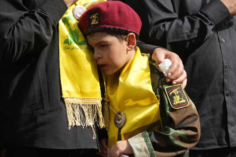 A boy cries during the funeral procession of two Hezbollah members in the southern suburbs of Beirut, Thursday, Sept. 19, 2024. (AP Photo/Hussein Malla)