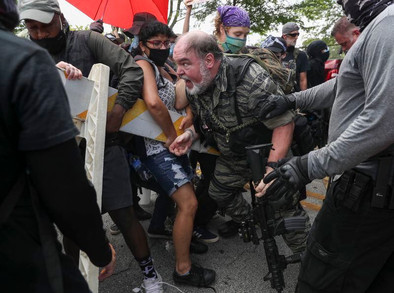 8/15/20 - Stone Mountain, GA - Protestors from both sides clash as several far-right groups, including militias and white supremacists, rally Saturday in the town of Stone Mountain, and a broad coalition of leftist anti-racist groups organized a counter-demonstration there after local authorities closed Stone Mountain park.   Alyssa Pointer / alyssa.pointer@ajc.com