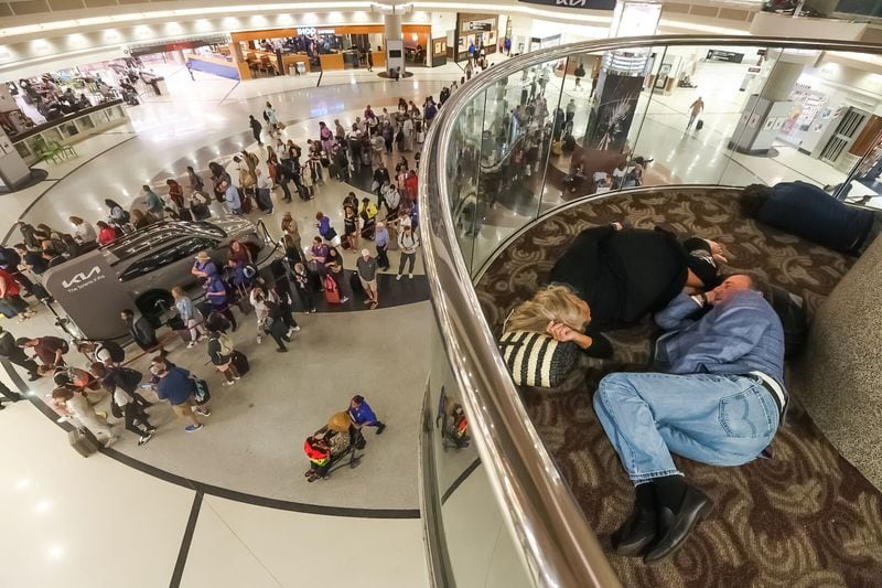 Passengers sleep at Hartsfield-Jackson International Airport early Monday.