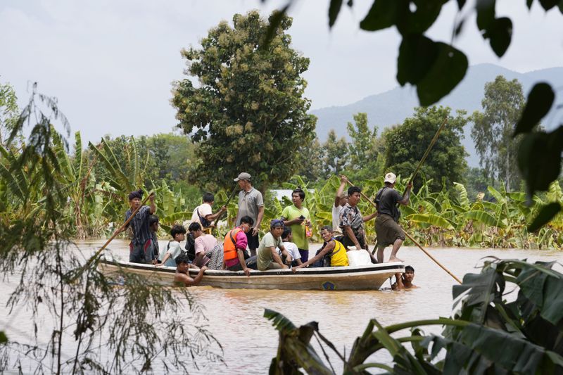 Local residents travel by boat on a flooded road in Naypyitaw, Myanmar, Saturday, Sept. 14, 2024. (AP Photo/Aung Shine Oo)