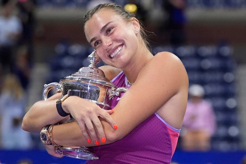 Aryna Sabalenka, of Belarus, poses for photos with the championship trophy after defeating Jessica Pegula, of the United States, in the women's singles final of the U.S. Open tennis championships, Saturday, Sept. 7, 2024, in New York. (AP Photo/Frank Franklin II)