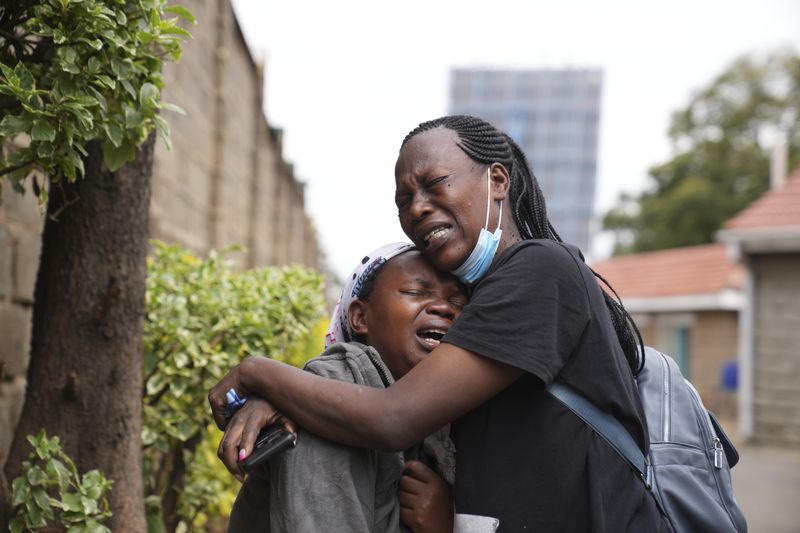 Edith Wanjiku, left, weeps after viewing the body of her son, who was allegedly shot by police during Tuesday's protest at the Nairobi funeral home, Kenya Wednesday, June 26, 2024. Thousands of protesters stormed and burned a section of Kenya's parliament Tuesday to protest tax proposals. Police responded with gunfire and several protesters were killed. (AP Photo/Brian Inganga)