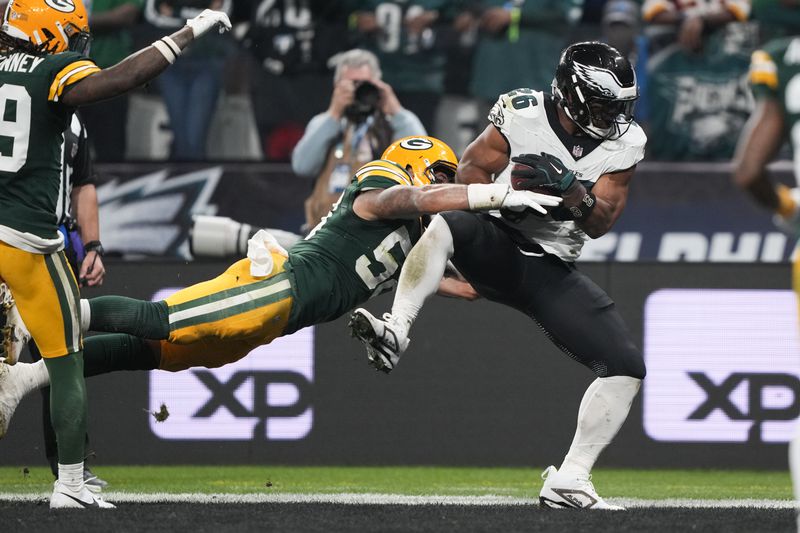 Philadelphia Eagles running back Saquon Barkley (26) scores past Green Bay Packers linebacker Isaiah McDuffie (58) during the first half of an NFL football game, Friday, Sept. 6, 2024, at the Neo Quimica Arena in Sao Paulo. (AP Photo/Doug Benc)