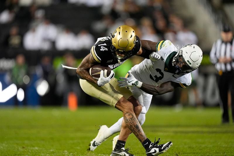 Colorado wide receiver Will Sheppard, left, is tackled by Baylor safety Devyn Bobby after pulling in a pass in the second half of an NCAA college football game Saturday, Sept. 21, 2024, in Boulder, Colo. (AP Photo/David Zalubowski)