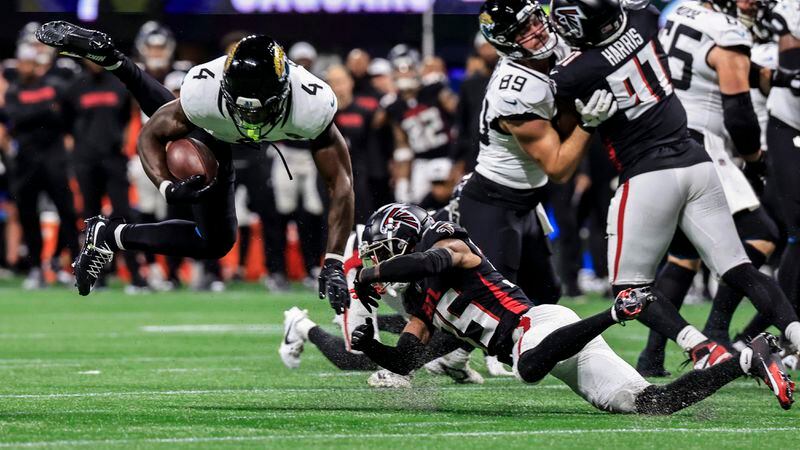 Atlanta Falcons cornerback Natrone Brooks (35) trips up Jacksonville Jaguars running back Tank Bigsby (4) in the first half of an NFL preseason footballl game, Friday, Aug. 23, 2024, in Atlanta. (AP Photo/Butch Dill)