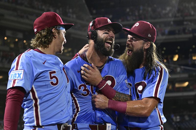 Philadelphia Phillies' Weston Wilson, center, celebrates after he was doused by teammates Brandon Marsh, right, and Bryson Stott after a victory over the Washington Nationals in a baseball game, Thursday, Aug. 15, 2024, in Philadelphia. (AP Photo/Derik Hamilton)