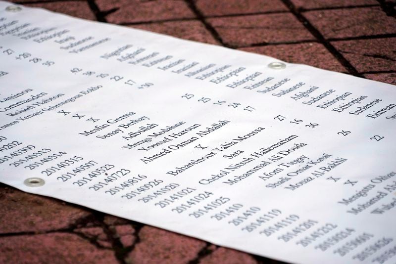 A list of names of migrants who are missing or died in the Calais region is seen in Calais, France, Wednesday, Sept 4, 2024. People gathered Wednesday to pay homage to the migrants who drowned on Tuesday when their small inflatable boat was ripped apart in the English channel. (AP Photo/Nicolas Garriga)