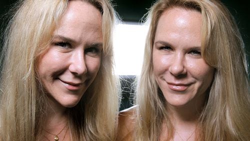 In this file photo, Anastasia, left, and Alexandria Duval, known as Alison and Ann Dadow before they changed their names, stand in the window of their yoga studio in West Palm Beach. (Thomas Cordy/The Palm Beach Post)