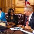 Georgia Election Board member Janelle King, center, speaks to executive director Mike Coan, right, before a board meeting at the Capitol in Atlanta on Friday, September 20, 2024. The election board is set to decide on sweeping rule changes less than a month before early voting begins. (Arvin Temkar / AJC)