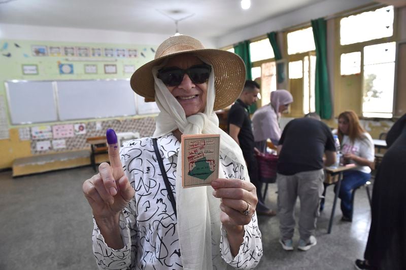 A voter poses for a photo with her inked finger after casting her ballot inside a polling station during the presidential elections, Saturday, Sept. 7, 2024, in Algiers, Algeria. (AP Photo/Fateh Guidoum)