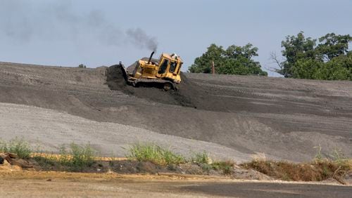 In this photo from 2011, a bulldozer is shown pushing a mound of coal ash at Plant McDonough near Smyrna. (Bob Andres // bandres@ajc.com)