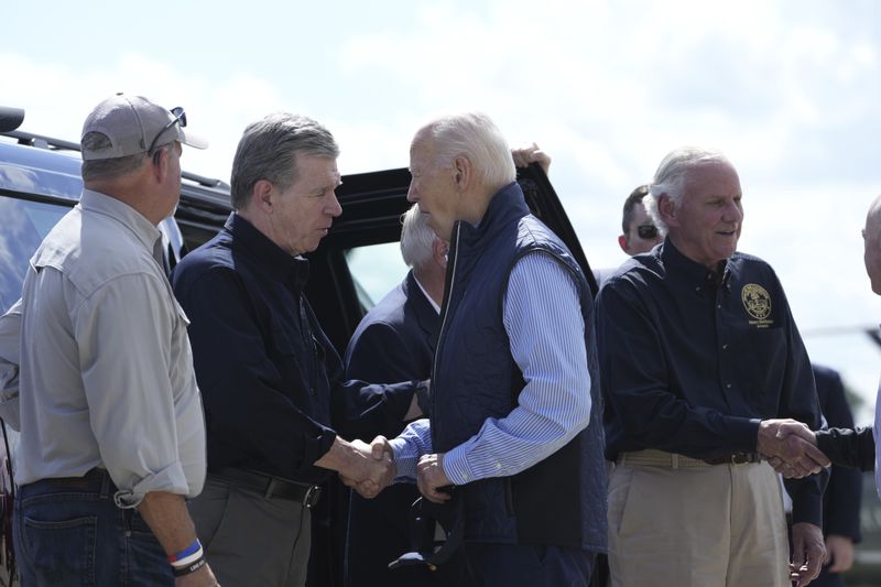 President Joe Biden shakes hands with Gov. Roy Cooper, D-N.C., with Gov. Henry McMaster, R-S.C., standing right, as he arrives at Greenville-Spartanburg International Airport in Greer, S.C., Wednesday, Oct. 2, 2024, to survey damage from Hurricane Helene. (AP Photo/Susan Walsh)