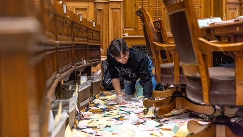 An employee of ICS Cleaners cleans the Senate after the legislative session in Atlanta on Sine Die, Wednesday, March 29, 2023. (Arvin Temkar / arvin.temkar@ajc.com)